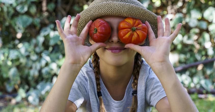 Petite fille tomates organiques fraîches devant ses yeuxjpg